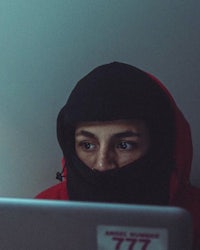 a man in a red hoodie using a laptop