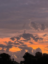 a photo of a sunset with clouds in the background